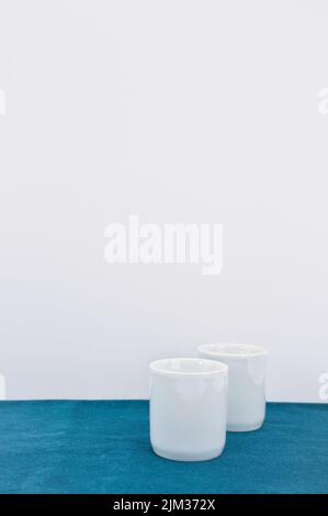 empty white bowl, vase on a green velvet table surface Stock Photo