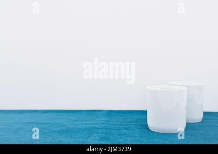 empty white bowl, vase on a green velvet table surface Stock Photo