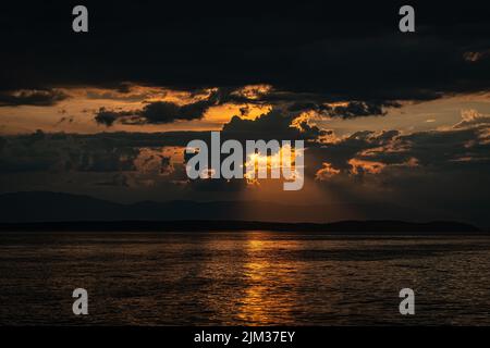 Sunset behind clouds off the Croatian coast. Stock Photo