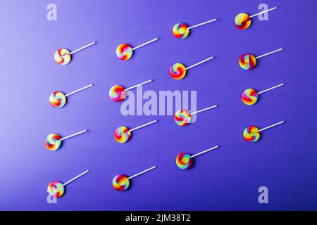 Overhead view of colorful lollipop candies arranged side by side on blue background Stock Photo