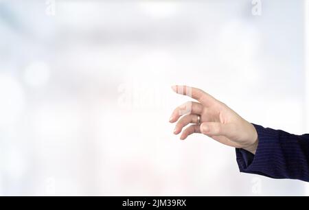 Hand pushing a button on a touch screen interface. Hand touching transparant projection screen in office Stock Photo