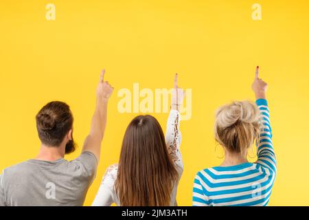 back view people row yellow backdrop showing up Stock Photo