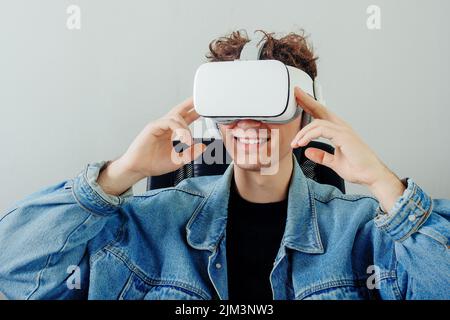 A happy handsome teenager with virtual reality equipment as a concept of VR technology Stock Photo
