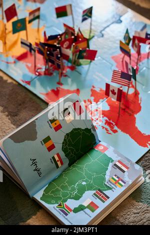 An open book and puzzle about the world and flags on a floor. Poznan ...