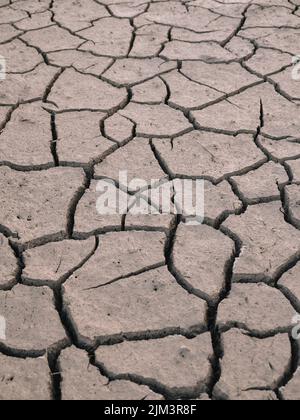 Cracked parched mud in a drought background - dry earth skin dry riverbed background Stock Photo
