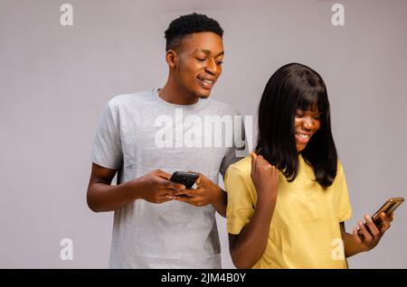 A Portrait of an African couple focused  and using gadgets spying on chatting cheating affair busted Stock Photo