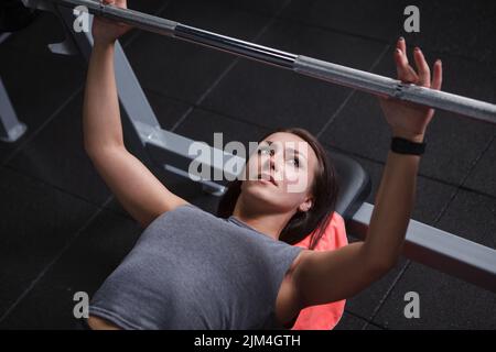 Top view cropped shot of a beautiful young sportswoman preparing for barbell bench press exercisr Stock Photo