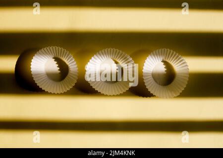 empty baking paper cups. white cookie paper cases isolated on yellow background with shadow Stock Photo