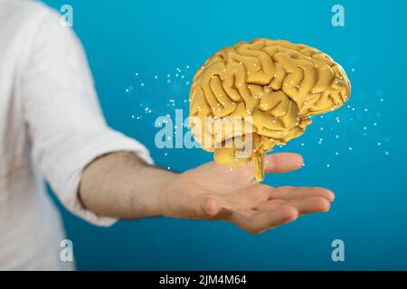 A person's hand with an illustrative brain floating above hands ...