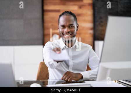 African Business Man Giving Paycheck Or Payroll Cheque Stock Photo