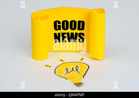 Business idea concept. A light bulb is drawn on a white background, next to it is a yellow plate with the inscription - GOOD NEWS Stock Photo