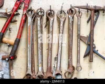 A closeup shot of rusty old tools hanging on a wall Stock Photo
