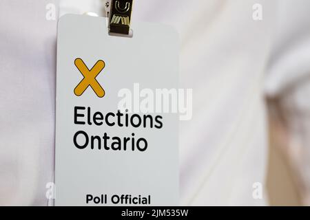 The Election Ontario logo is seen closeup on the badge of a Poll Official working for Elections Ontario. Stock Photo
