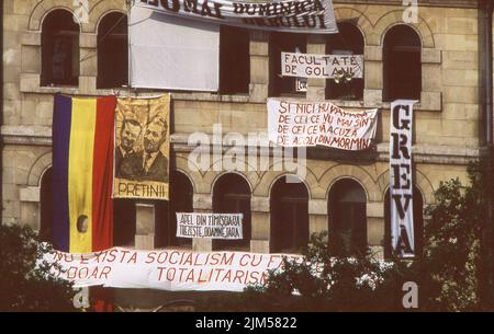 Bucharest, Romania, April 1990. 'Golaniada', a major anti-communism protest  in the University Square following the Romanian Revolution of 1989. People would gather daily to protest the ex-communists that took the power after the Revolution. Various banners are hanging on the walls of the University building. Stock Photo