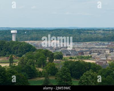 A telephoto view looking at a new residential development, a large neighbourhood of homes; a water town is seen in the background. Stock Photo