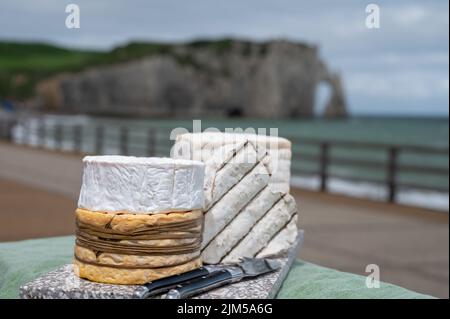 Four famous cheeses of Normandy, squared pont l'eveque, round camembert cow cheese, yellow livarot, heartshaped neufchatel and view on promenade and a Stock Photo