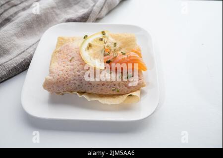 Cuisine of Normandy, galette pancake filled with goat cheese and smoked salmon served with fresh lemon, France Stock Photo