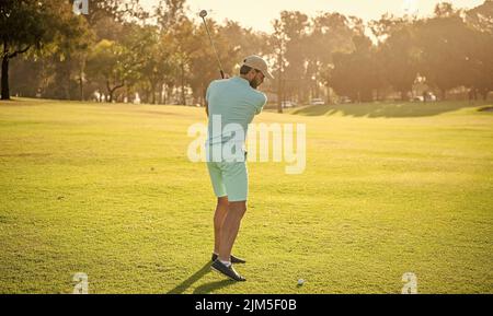 back view of male golf player on professional course with green grass, recreation Stock Photo