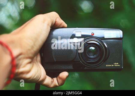 Close up of hand holding analog pocket camera Stock Photo