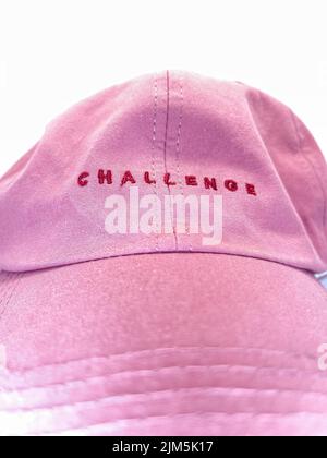 The written word challenge was isolated in a pink color cap. Selective focus. Isolated on white background. women or girl power concept. Shot on April Stock Photo