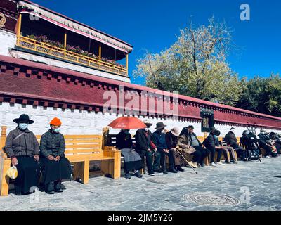 A beautiful shot of people sitting in a line in Potala Palace Fortress in Lhasa, China Stock Photo