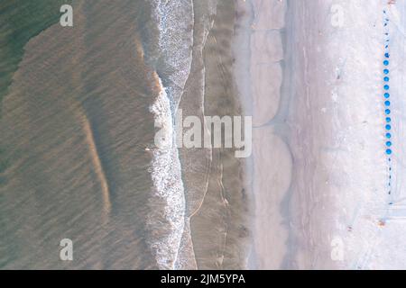 A bird's-eye view of the waves, deck chairs with blue umbrellas at Hilton Head Island beach,South Carolina Stock Photo