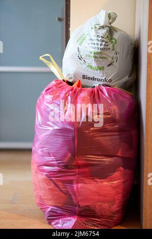 A vertical closeup of two plastic bags with clothes and garbage stacked on top of each other. Stock Photo