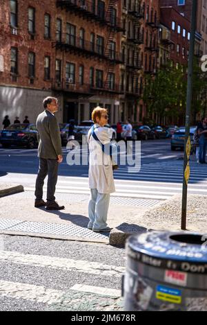 A vertical shot of the people waiting to cross the street. Chelsea Market, New York, USA. Stock Photo