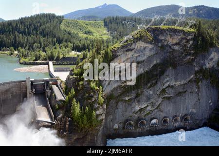 Aerial view of the concrete arch hydro-electric Boundary Dam spilling water on the Pend-Oreille River, flowing into Canada, in Washington State, USA. Stock Photo