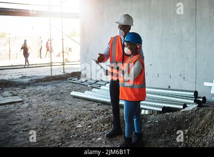 Profitable relationships are built on a foundation of trust. a young man and woman having a discussion while working at a construction site. Stock Photo