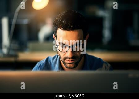 IT guy working with computer late at night, searching online while planning, thinking strategy or typing out deadline. Business man with glasses Stock Photo