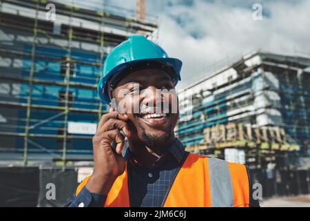 Making positive moves for a winning project. a young man using a smartphone while working at a construction site. Stock Photo