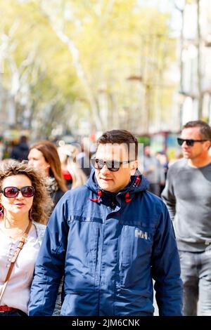 Barcelona, Spain- April 4, 2022:People walking along the ramblas in Barcelona (Spain), the busiest street in the city. Stock Photo