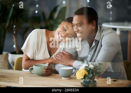 Love as warm as a fresh cuppa. a young couple spending time together at a cafe. Stock Photo