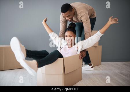 Filling their new home with tons of laughter. a young couple having fun while moving house. Stock Photo