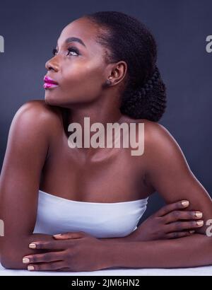 Be the woman you would look up to. Studio shot of a beautiful young woman posing against a black background. Stock Photo