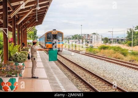 A train pulls into a station and waits for passengers in Thailand Stock Photo