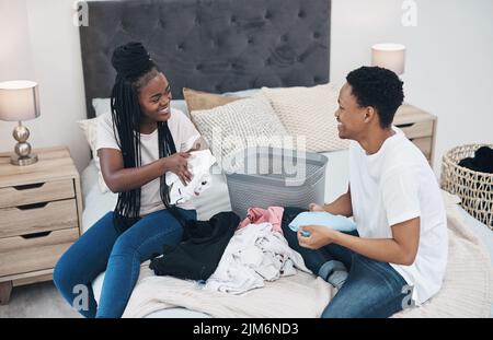 Winning in lockdown takes doing the laundry together. a young couple doing laundry together at home. Stock Photo