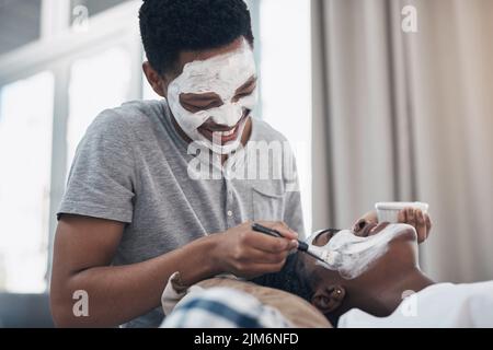 Quarantine dates take a bit of creativity. a young couple getting homemade facials together at home. Stock Photo