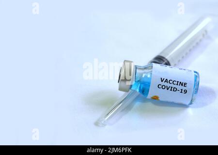 Selective focus coronavirus COVID 19 vaccine vial on white background and blurred syringe Stock Photo
