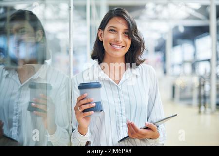 A small device that holds a huge business network. a young businesswoman using a digital tablet in a modern office. Stock Photo