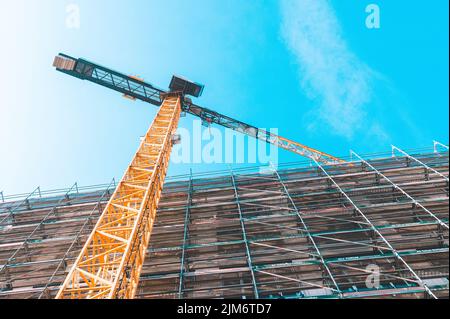 A low angle shot of a crane with equipment on a construction site with ...