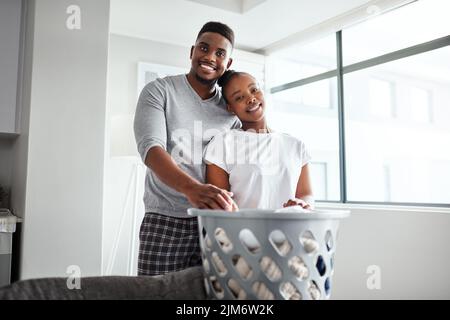 Who said laundry day cant be a leisurely one. a happy young couple doing laundry together at home. Stock Photo