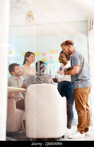 Achieving bigger goals together. a group of young creatives working together in an office. Stock Photo