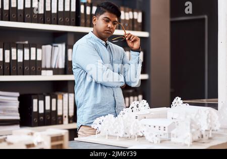 Laying the groundwork for a successful project. a young architect designing a building model in a modern office. Stock Photo