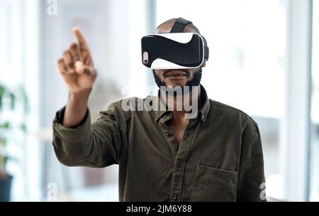 Experience business like never before. a young businessman using a virtual reality headset in a modern office. Stock Photo