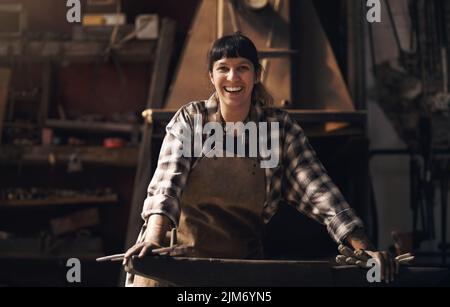 The best blacksmith in the business. Portrait of a confident young woman working at a foundry. Stock Photo