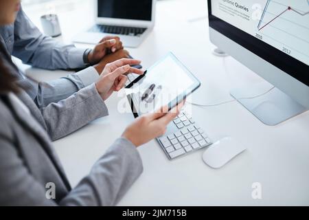 Accounting kept simple with smart software. a businessman using a digital tablet to analyse financial data in a modern office. Stock Photo