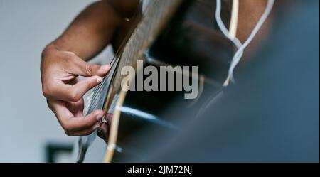 I pick the guitar over anything any day. a man playing the guitar in his bedroom at home. Stock Photo