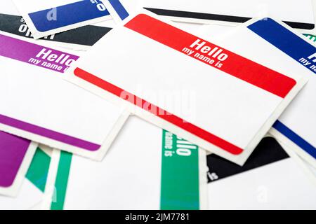Full frame on pile of colorful blank "hello my name is" adhesive paper ID tags with copy space concept for corporate meet and greet event, conversatio Stock Photo
